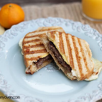 Sausage egg and cheese panini on a decorative plate.