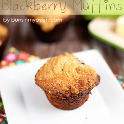 A close up of a blackberry muffin on a white square plate.