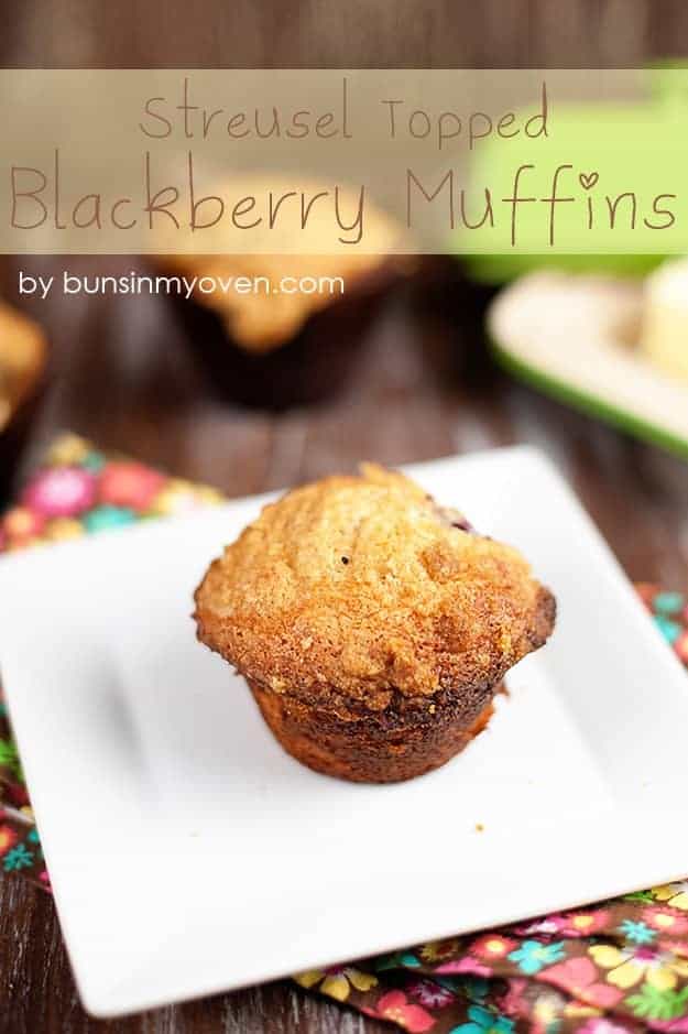 A blackberry muffin on a square white plate.