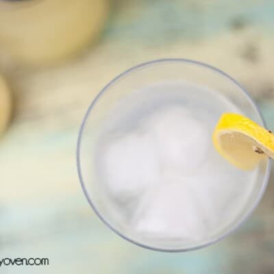 An overhead view of iced vodka in a glass with lemon on the rim.