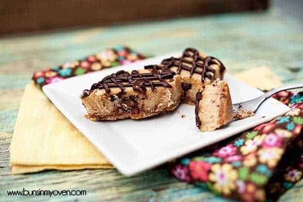 A few peanut butter cup cheesecake bars on a plate.