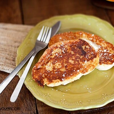 Eggnog french toast topped with syrup on a decorative plate.