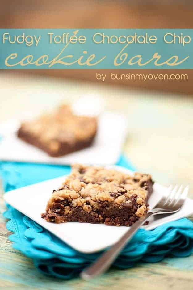 A toffee cookie bar on a square white plate with a fork.