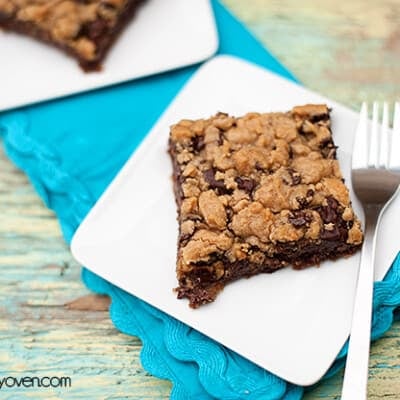 A chocolate cookie bar on a square white plate.