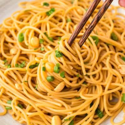 Thai peanut noodles on chopsticks.