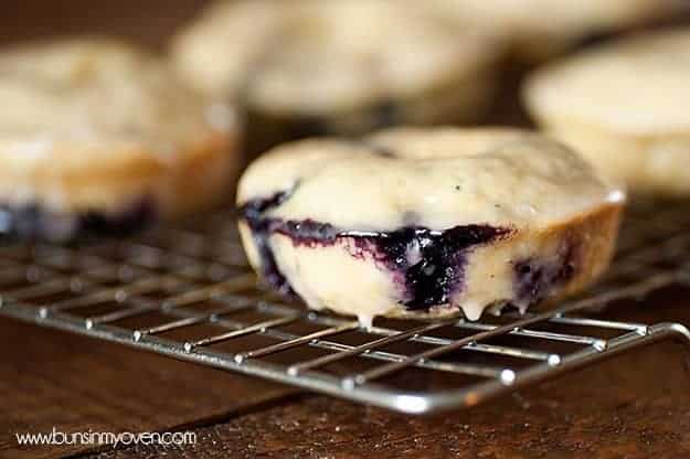 A close up of a blueberry donut on a wire cooling rack.
