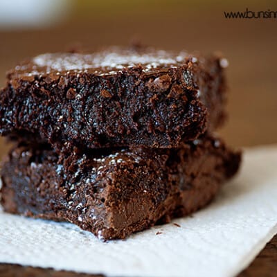 Two brownies stacked on a paper napkin.