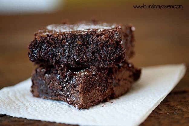 Two brownies stacked on a paper napkin.