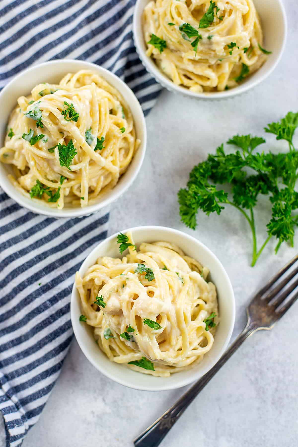 creamy pasta recipe in white bowls.