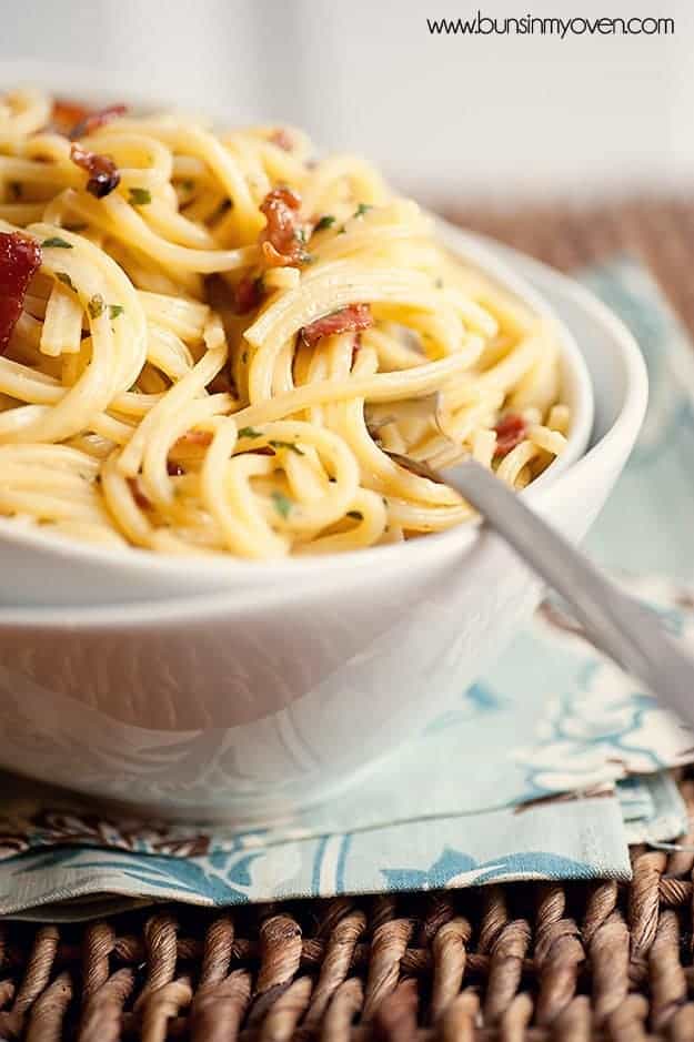 A close up of a fork stabbed into a bowl of pasta
