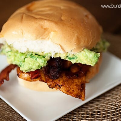 A chicken sandwich on a white square plate.