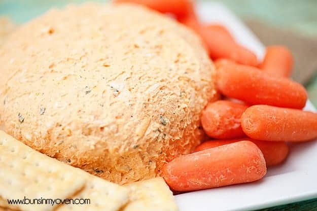 A cheeseball surrounded by baby carrots