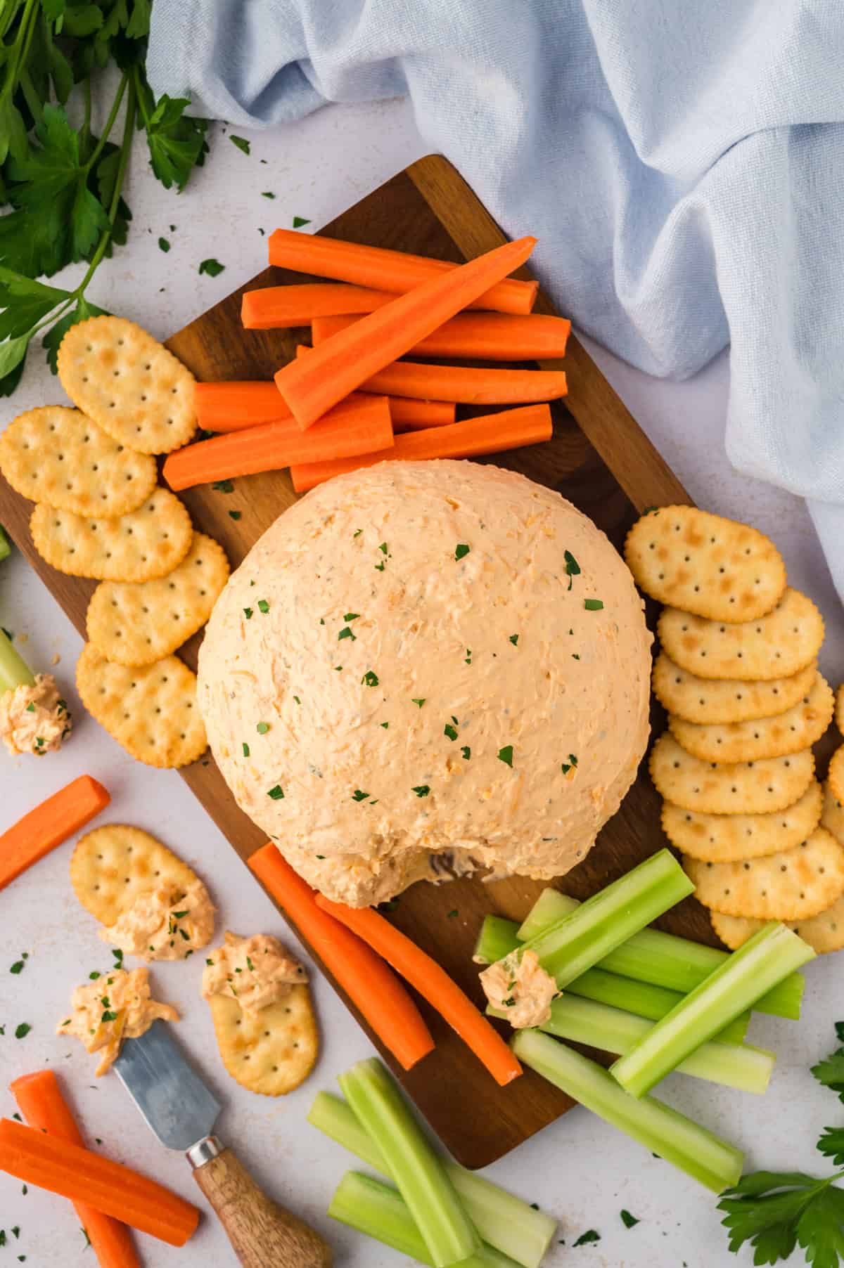 A cheeseball surrounded by baby carrots