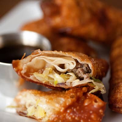 A close up of a sausage egg roll split in half.
