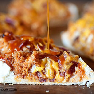 barbecue sauce being drizzled over chicken bread.