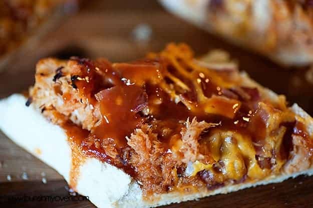 A close up of chicken bread topped with barbecue sauce.