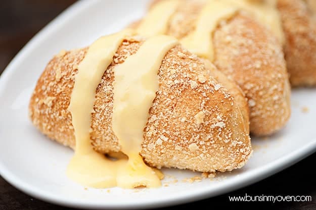 A couple chicken stuffed biscuits on a white plate.