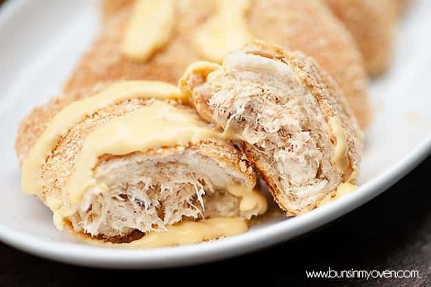 A chicken stuffed biscuit split in half on a white plate.