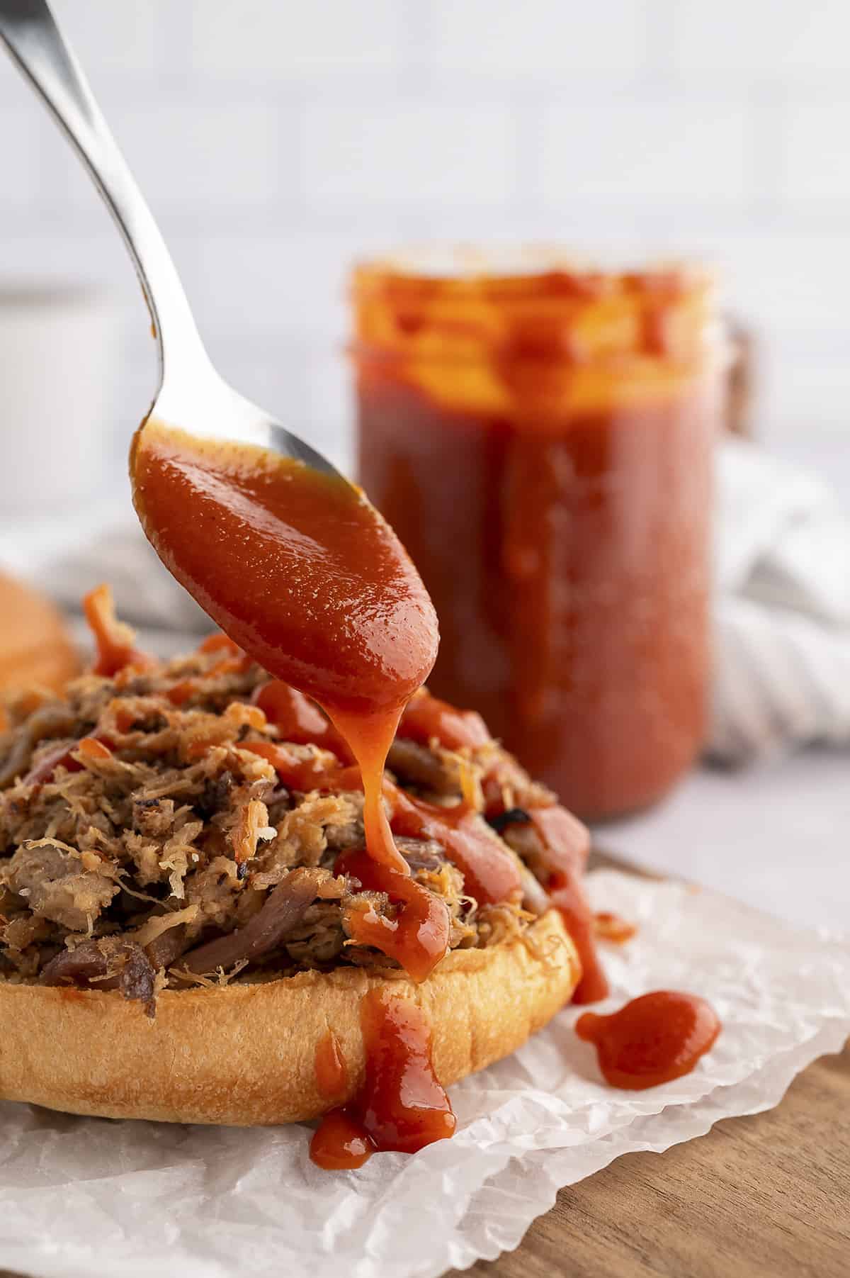 Sauce being drizzled on sandwich.