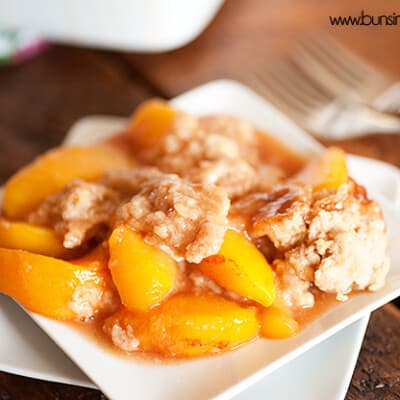 Peach cobbler on a square white plate.