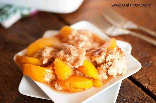 Peach cobbler on a square white plate.