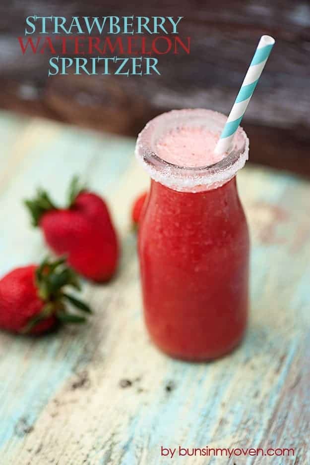 A small jar of strawberry spritzer in front of strawberries.