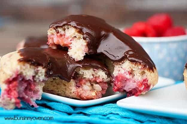A raspberry donut with chocolate frosting split in half.