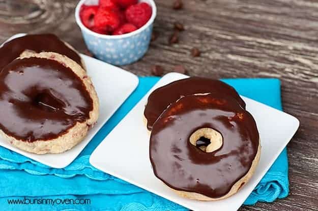 Two plates of chocolate donuts on a blue cloth napkin