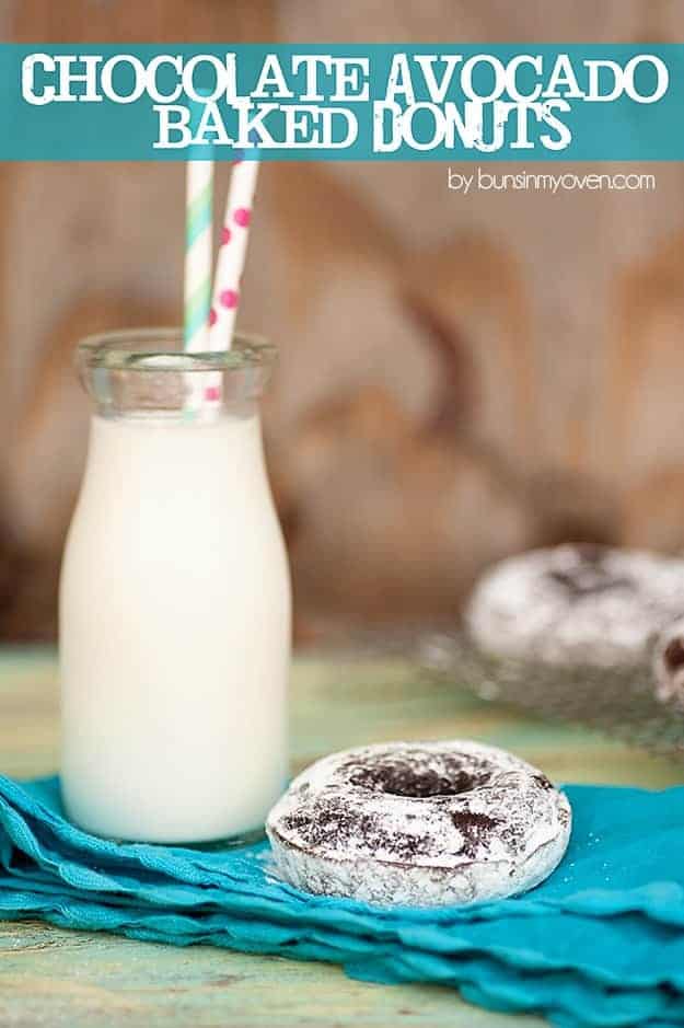 A jar of milk next to a chocolate donut 