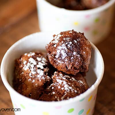 A closeup of the paper cup full of fried cookie dough balls