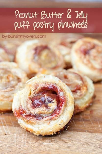 The pile of peanut butter and jelly pinwheels on a wooden cutting board 