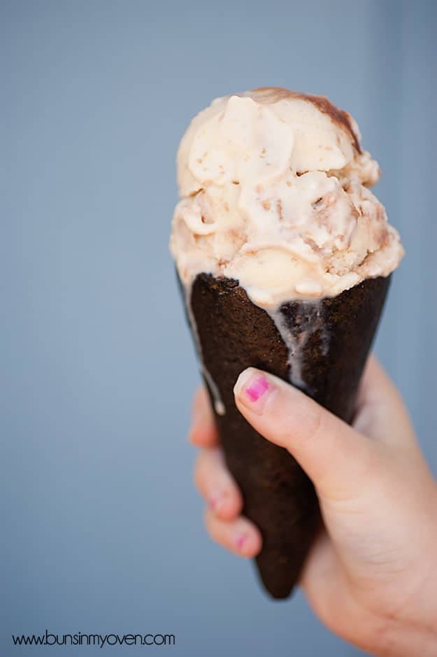 A closeup of a girl holding up an ice cream cone 
