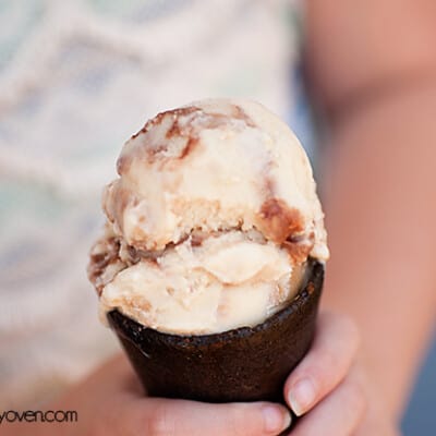 A girl holding up an ice cream cone to the camera