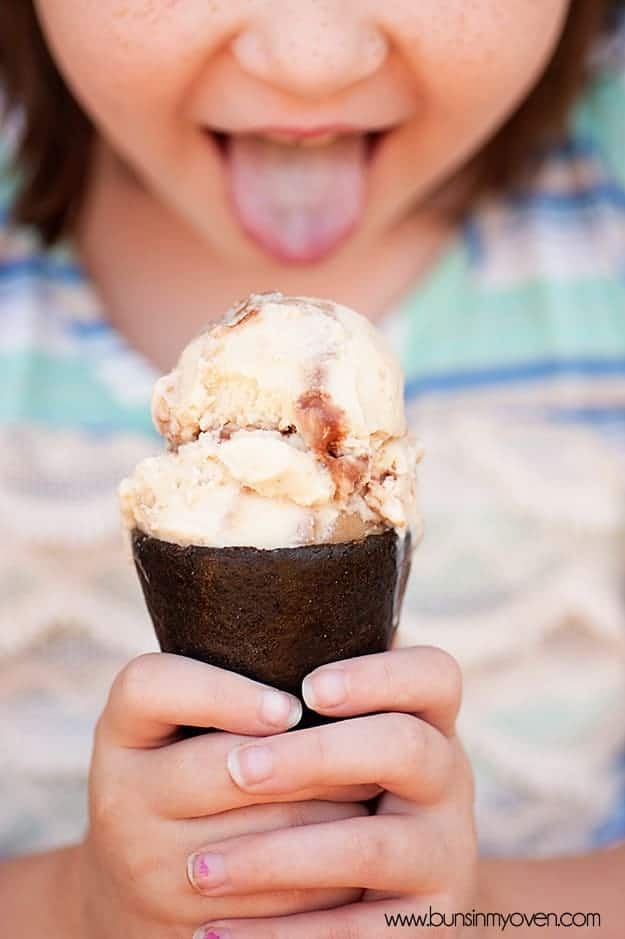 A girl sticking her tongue out to lick some ice cream 