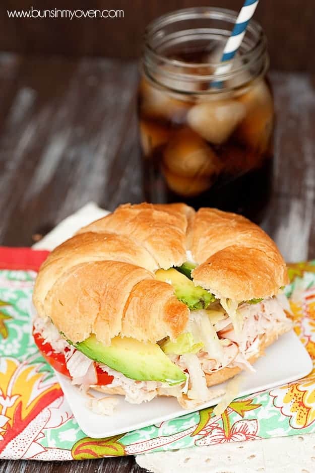 A close up of a sandwich sitting on a square white plate