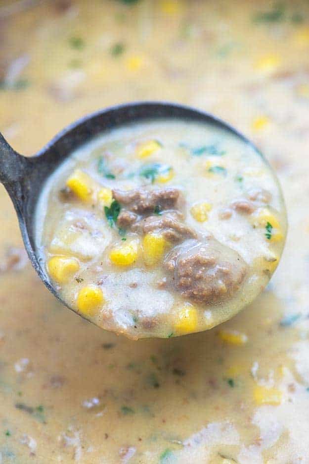 A ladle scooping soup out of a pot.