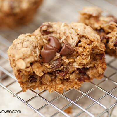 An oatmeal cookie cut in half on a cooling rack.