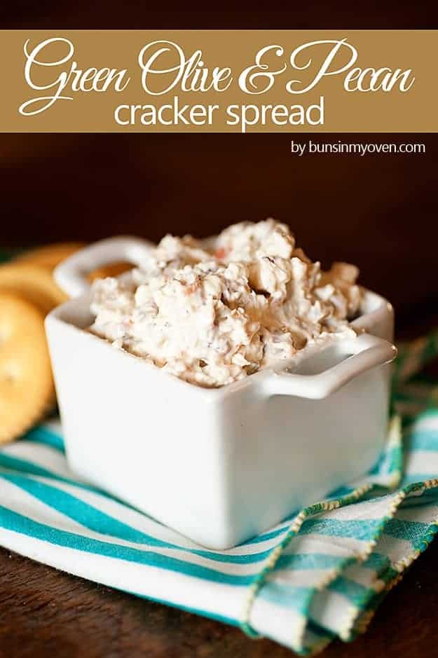 A small white dish full of olive spread in front of Ritz crackers.