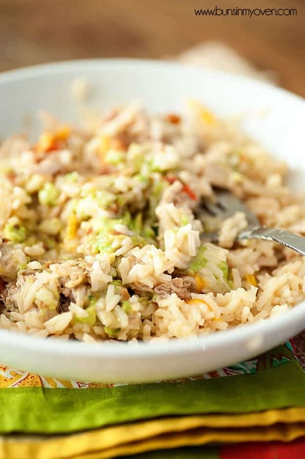 A white bowl with pork and rice in it.