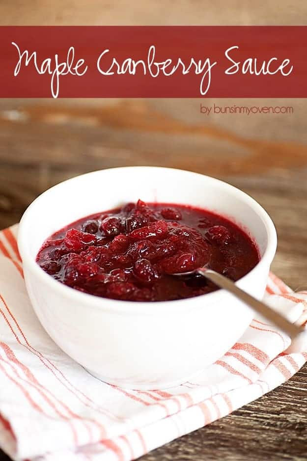 A white bowl of cranberry sauce with a spoon in it.