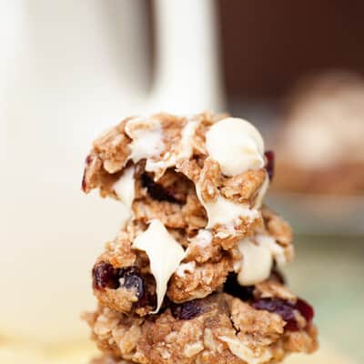 A stack of oatmeal cranberry breakfast cookies with a bite taken out of the top cookie.