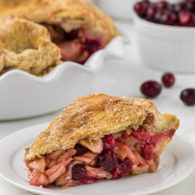 Slice of cranberry apple pie on small dessert plate.