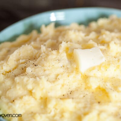 A close up of an overhead picture of melted butter on top of mashed potatoes.