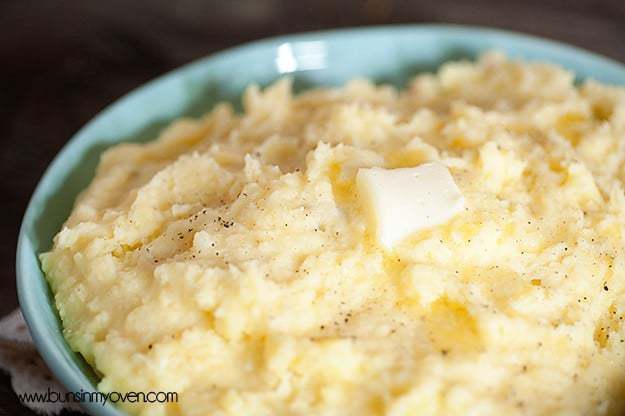 A close up of an overhead picture of melted butter on top of mashed potatoes.