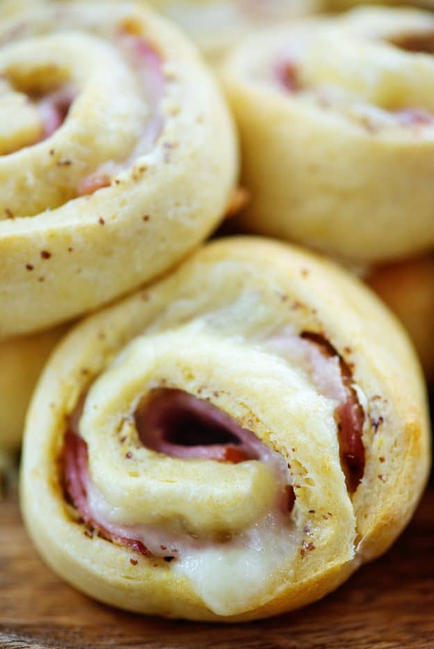 close up of ham and swiss pinwheel on board.