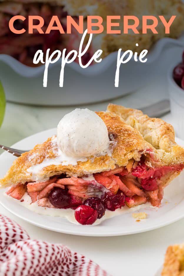 Slice of apple cranberry pie with scoop of vanilla ice cream melting over the top.