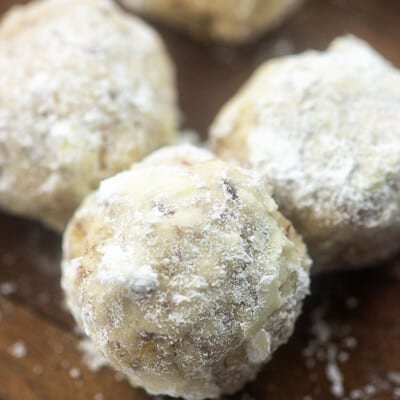 Three cookie balls covered in powdered sugar.