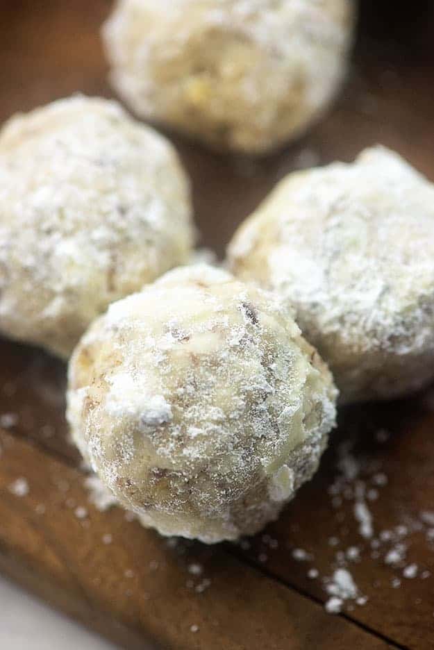 Three cookie balls covered in powdered sugar.