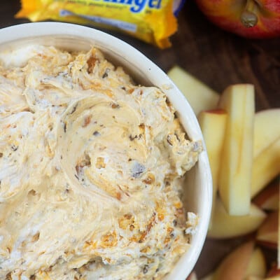 Butterfinger dip in a bowl near sliced apples.