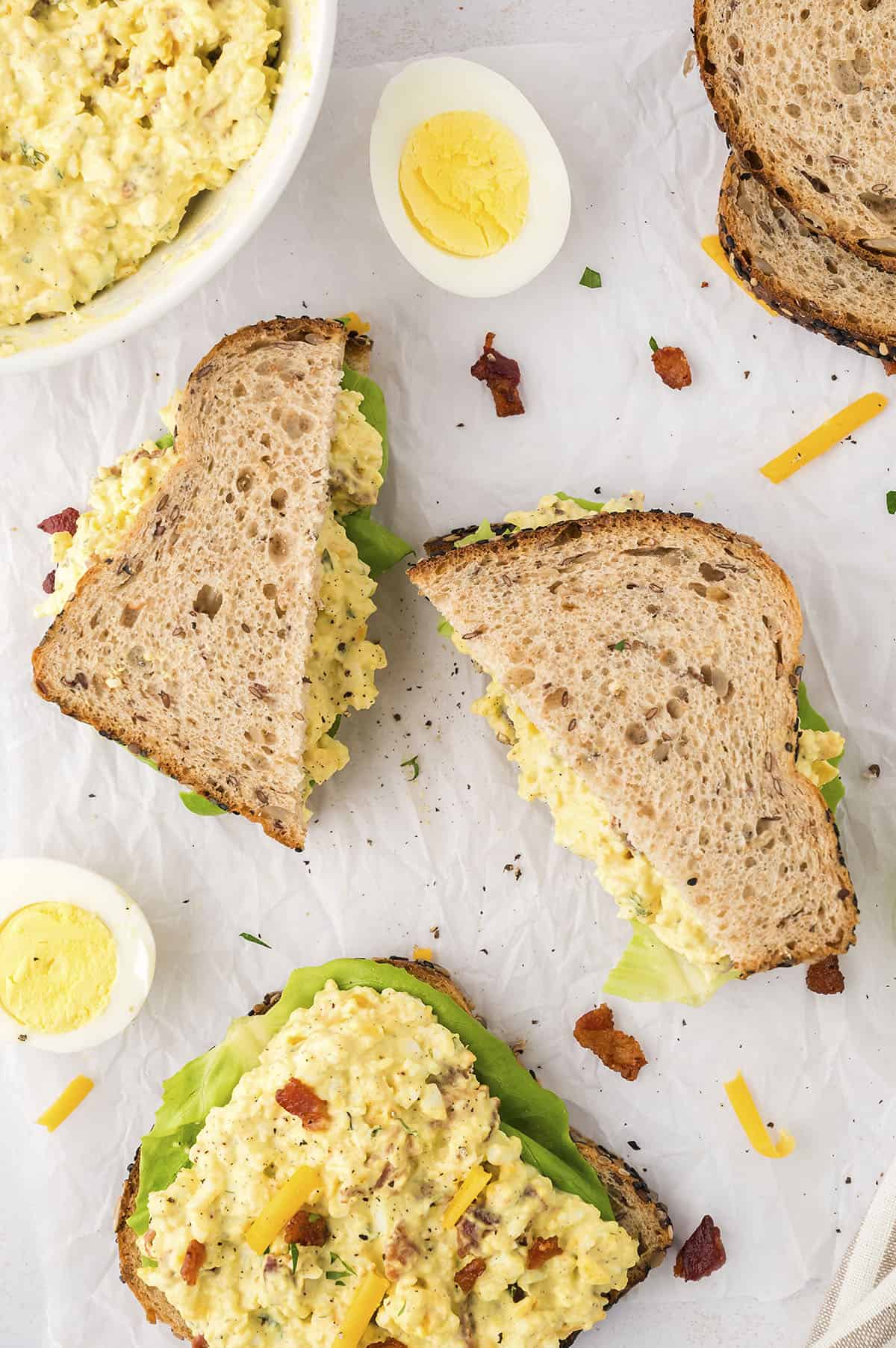 Egg salad made with cheddar and bacon on sandwich bread.